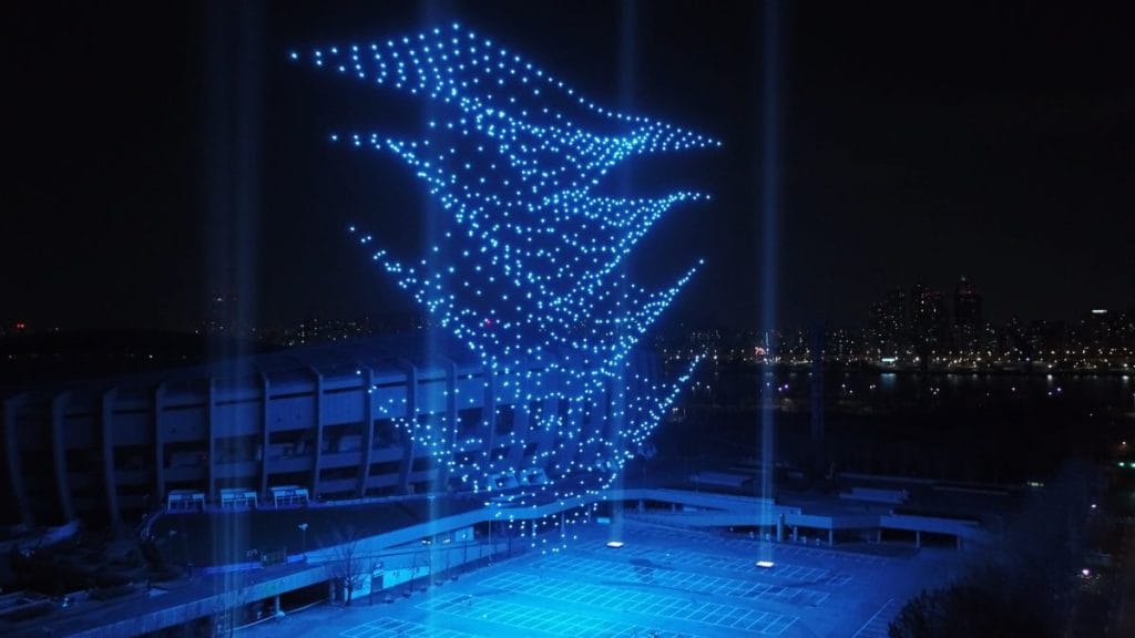 Blue drones descending inside an exhibition hall