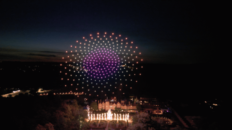 Pyrotechnic finale beneath a multicoloured drone formation